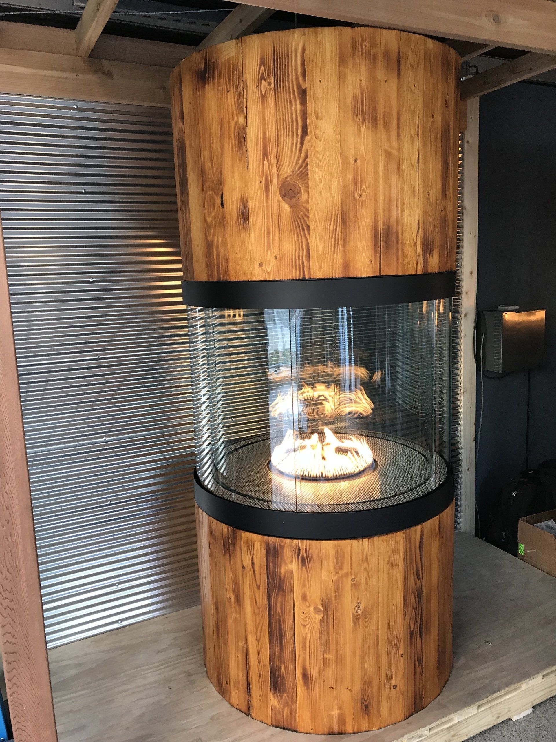 A large wooden cylinder with a fire inside of it