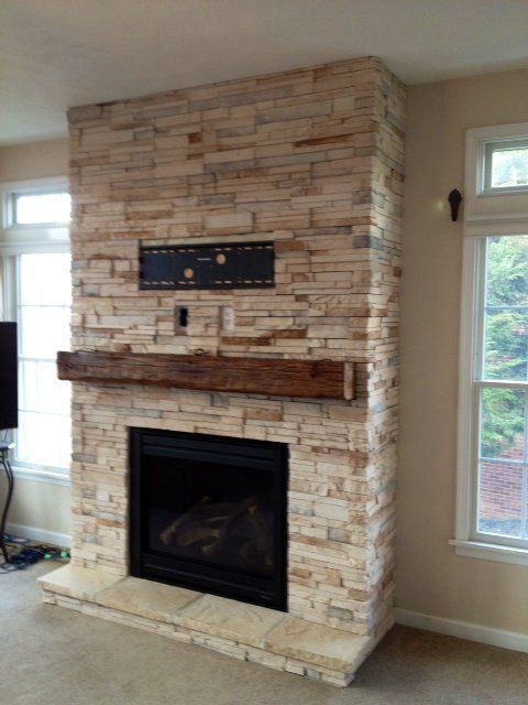 A brick fireplace with a wooden mantle in a living room