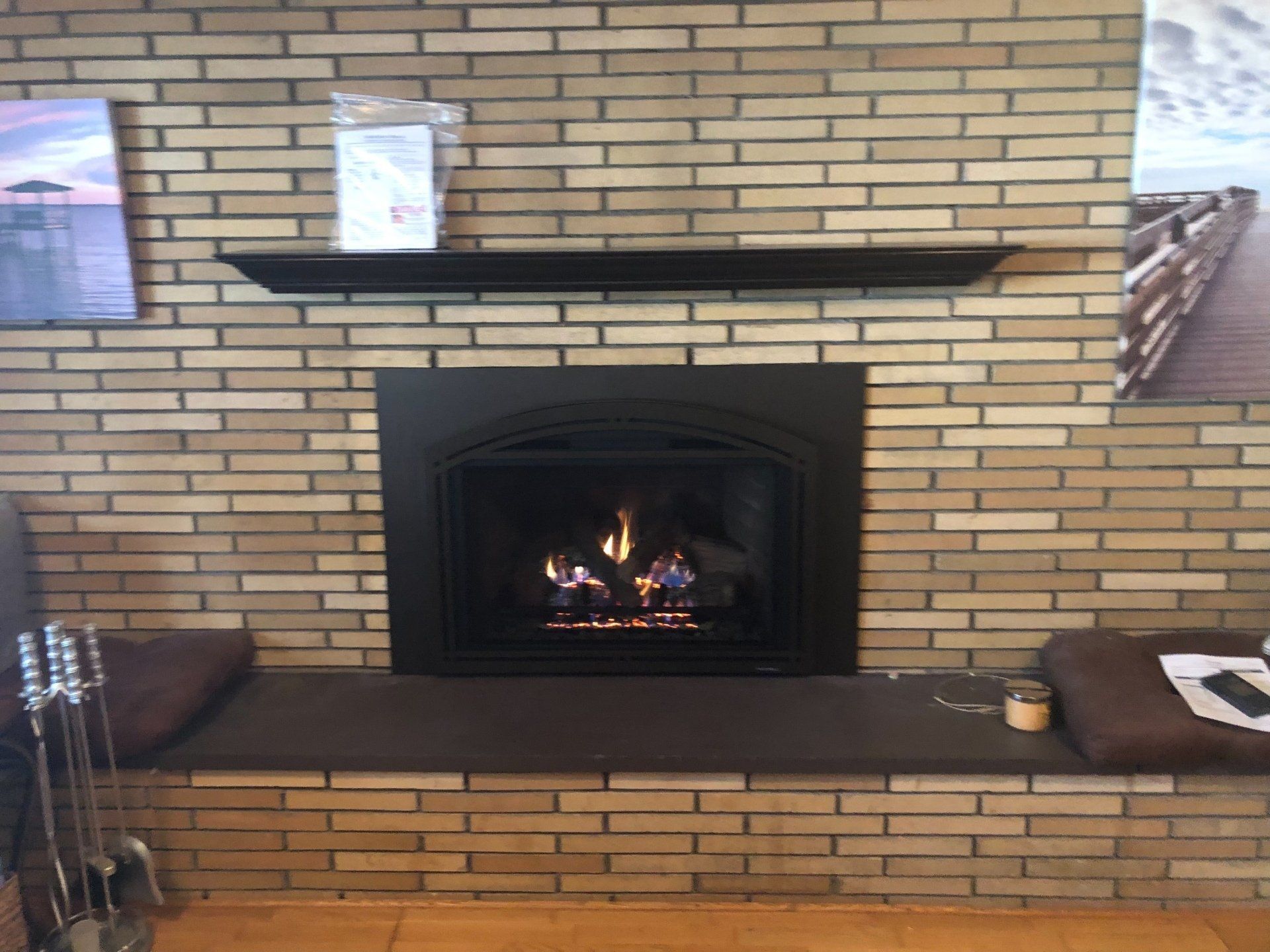 A fireplace in a brick wall with a bench underneath it