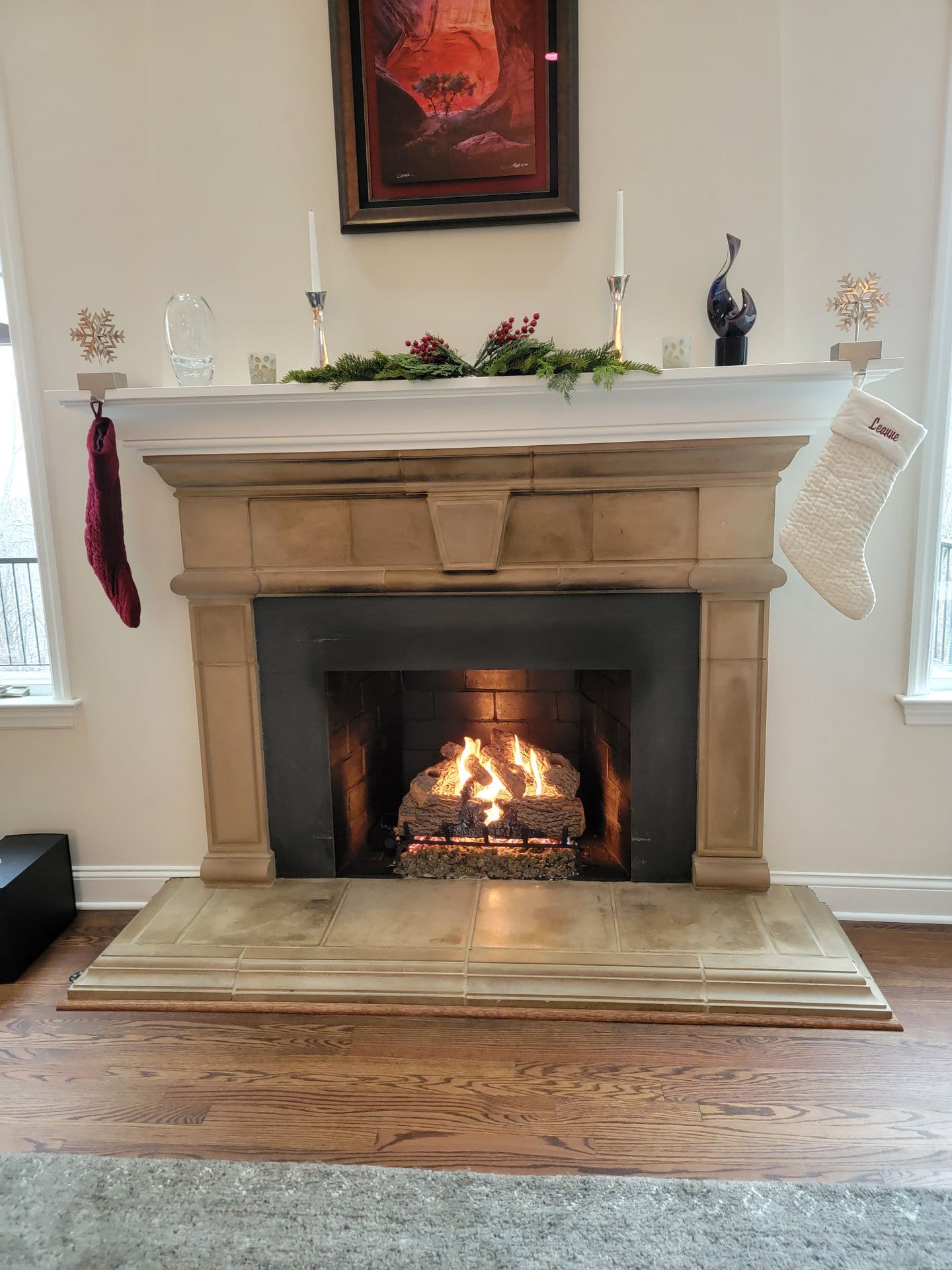 A living room with a fireplace and a christmas stocking on the mantle.