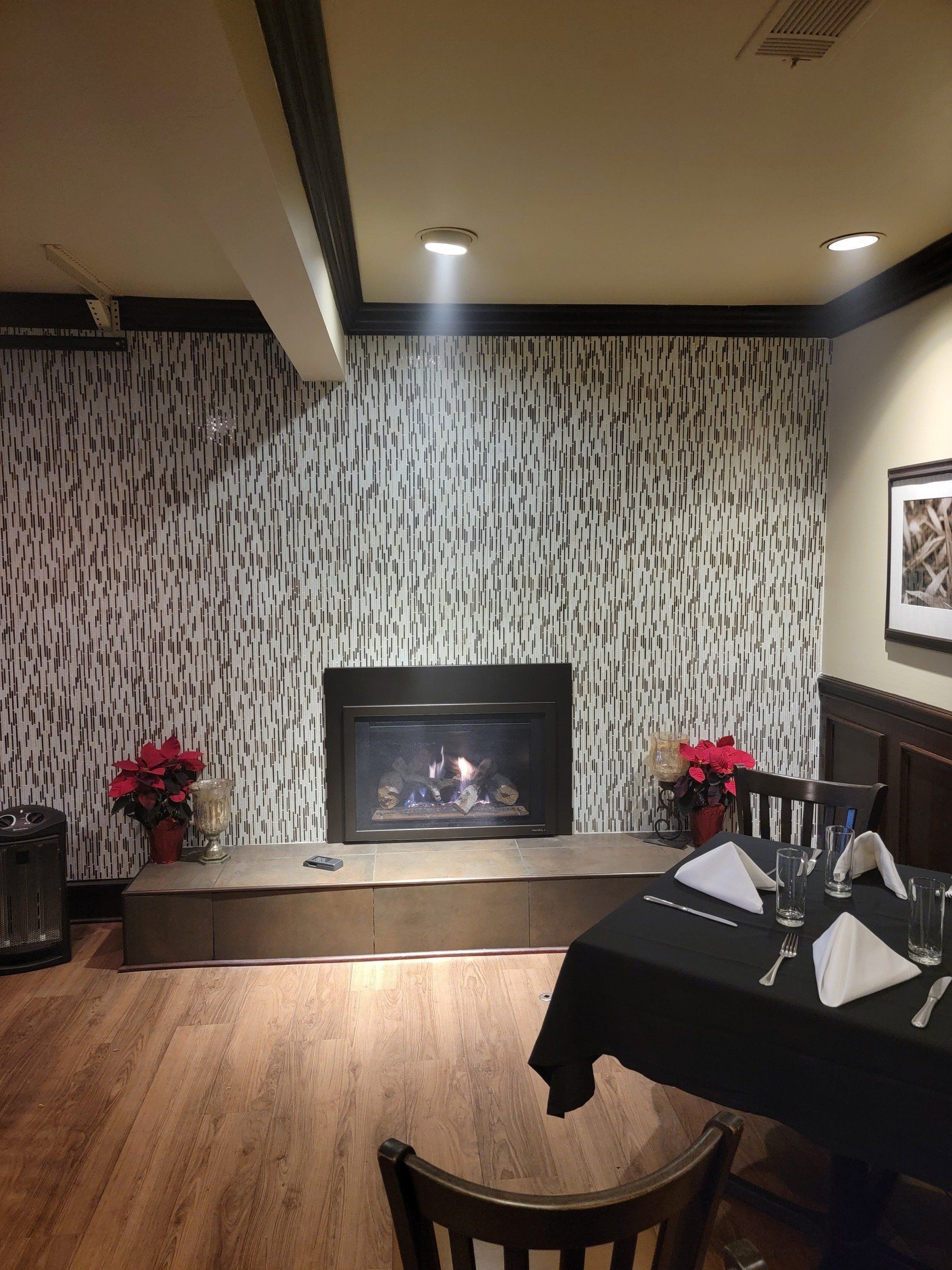 A dining room with a table and chairs and a fireplace