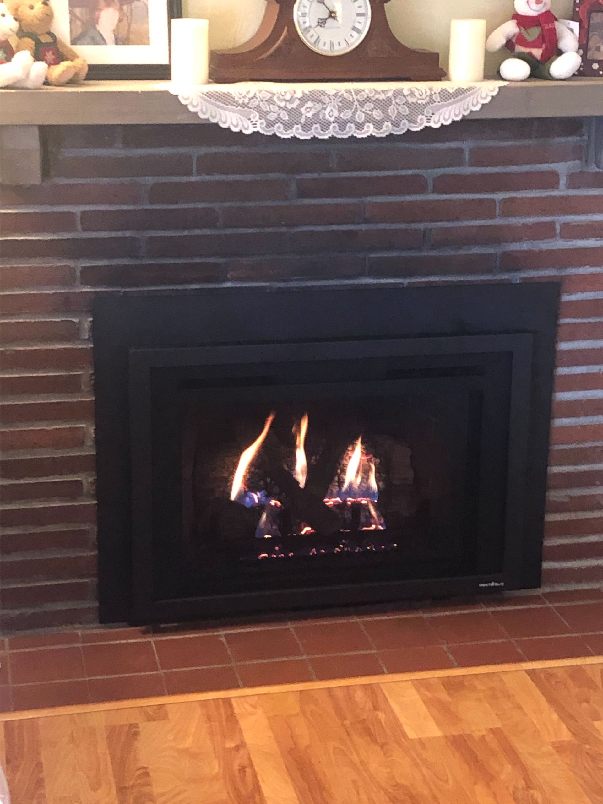 A living room with a fireplace and a clock on the mantle.