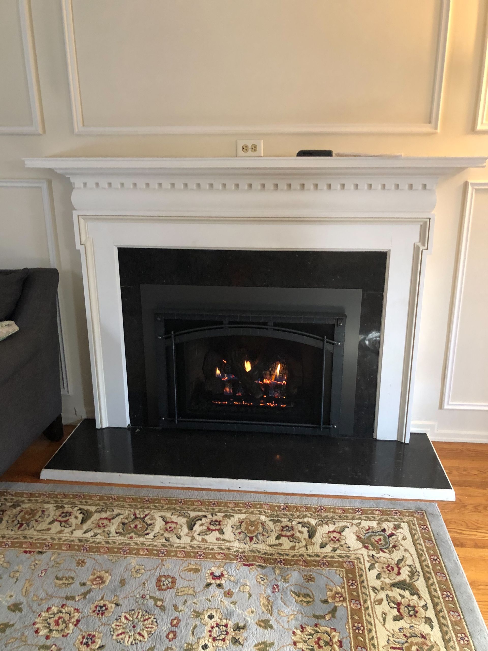 A living room with a fireplace and a rug