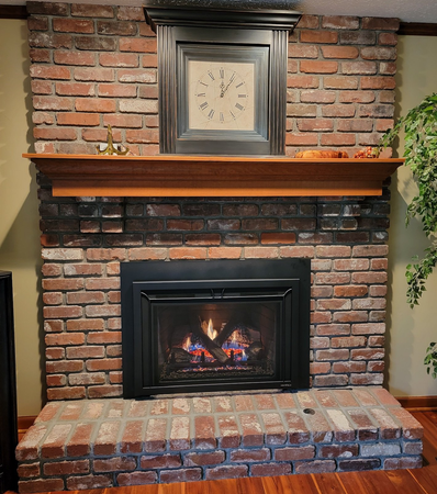 A brick fireplace with a clock above it