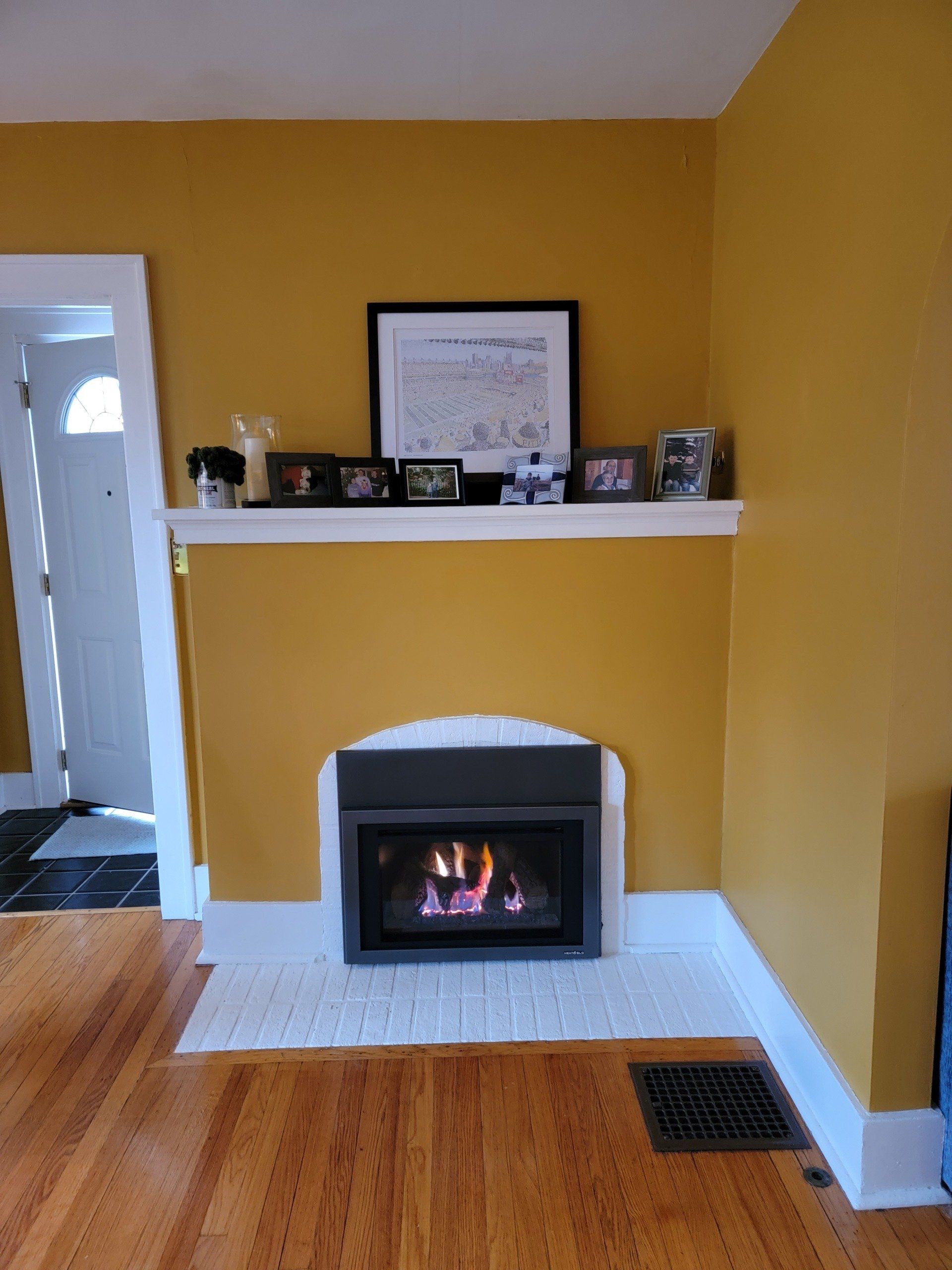 A living room with yellow walls and a fireplace