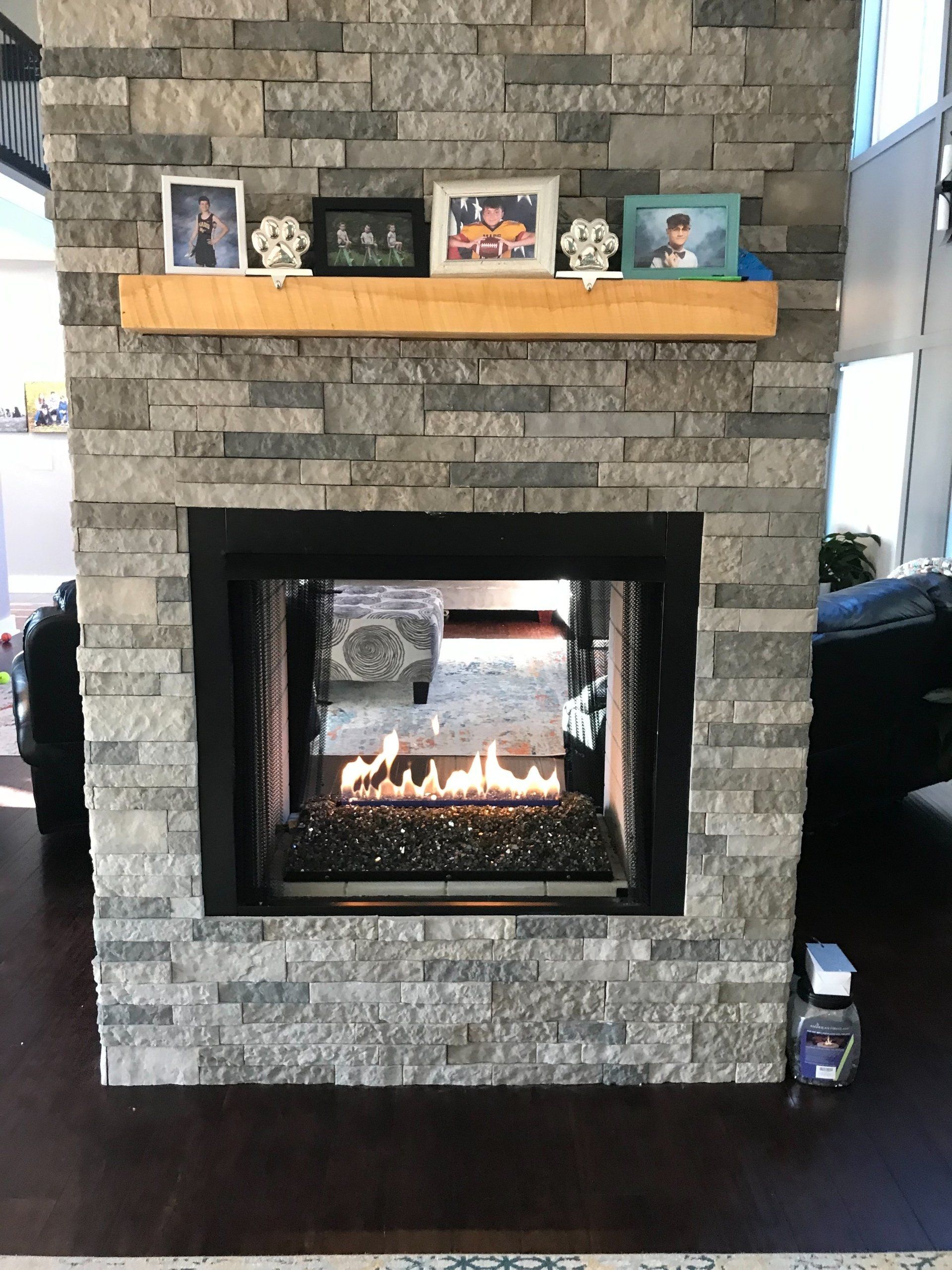 A fireplace in a living room with pictures on the mantle