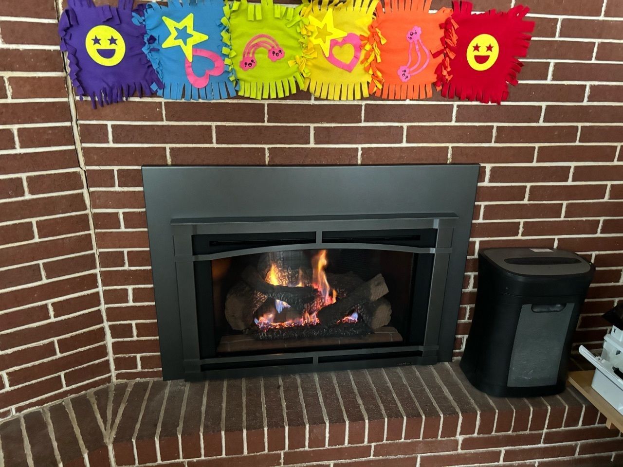 A fireplace with a rainbow of smiley faces on it