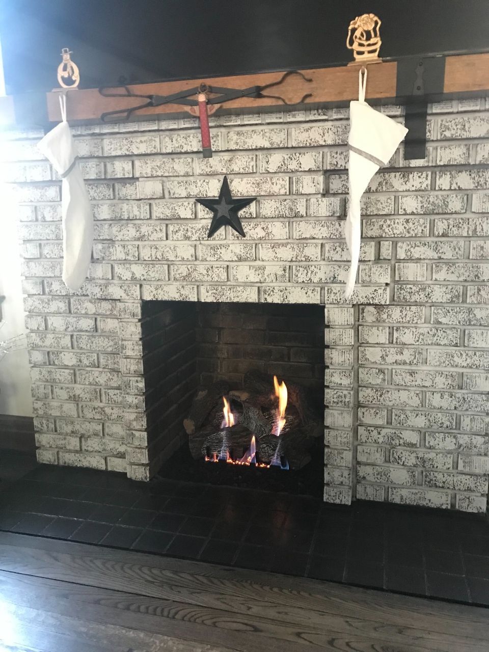 A brick fireplace with christmas stockings hanging from the mantle