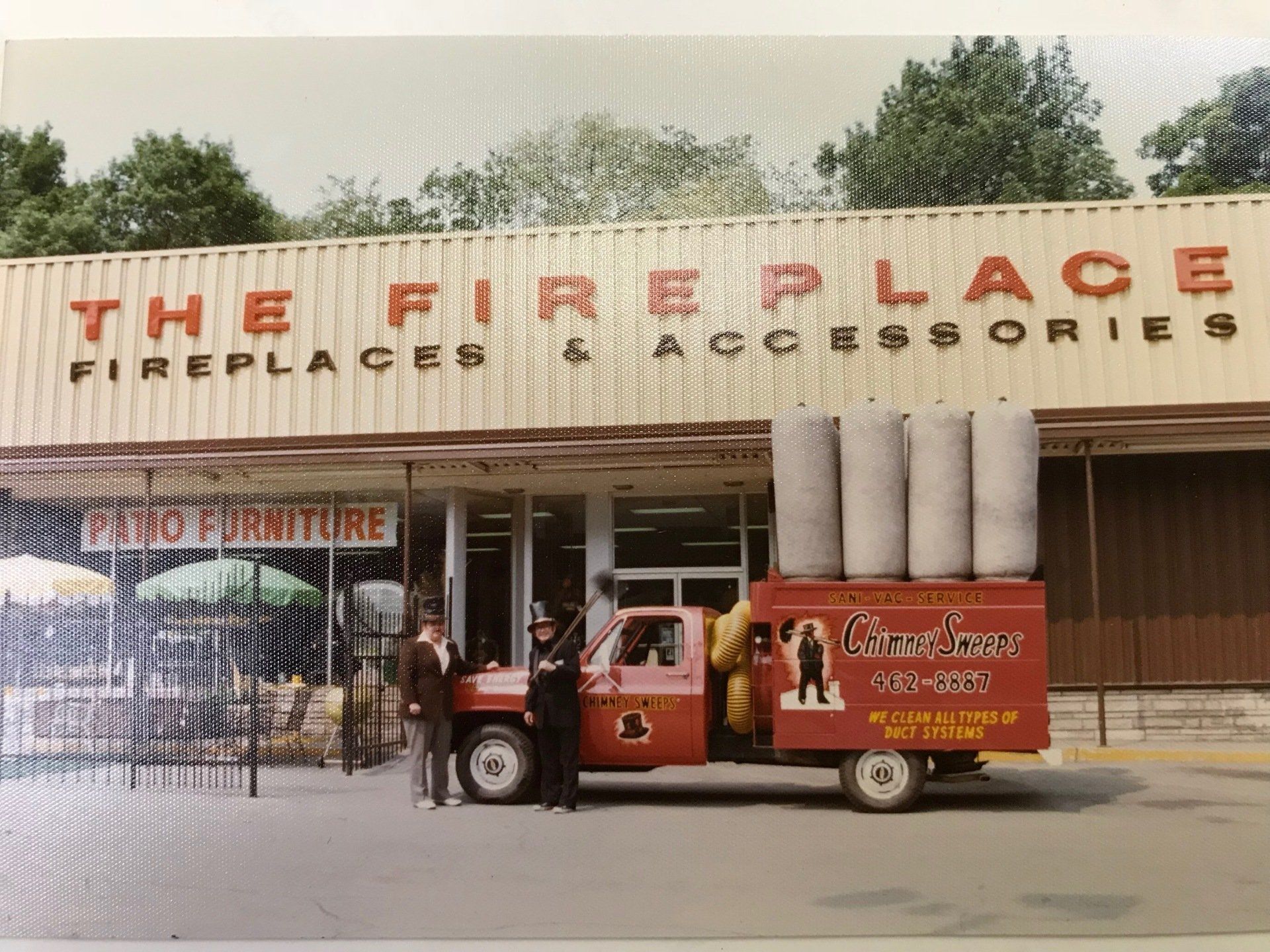 A red truck is parked in front of the fire place fireplace and accessories store