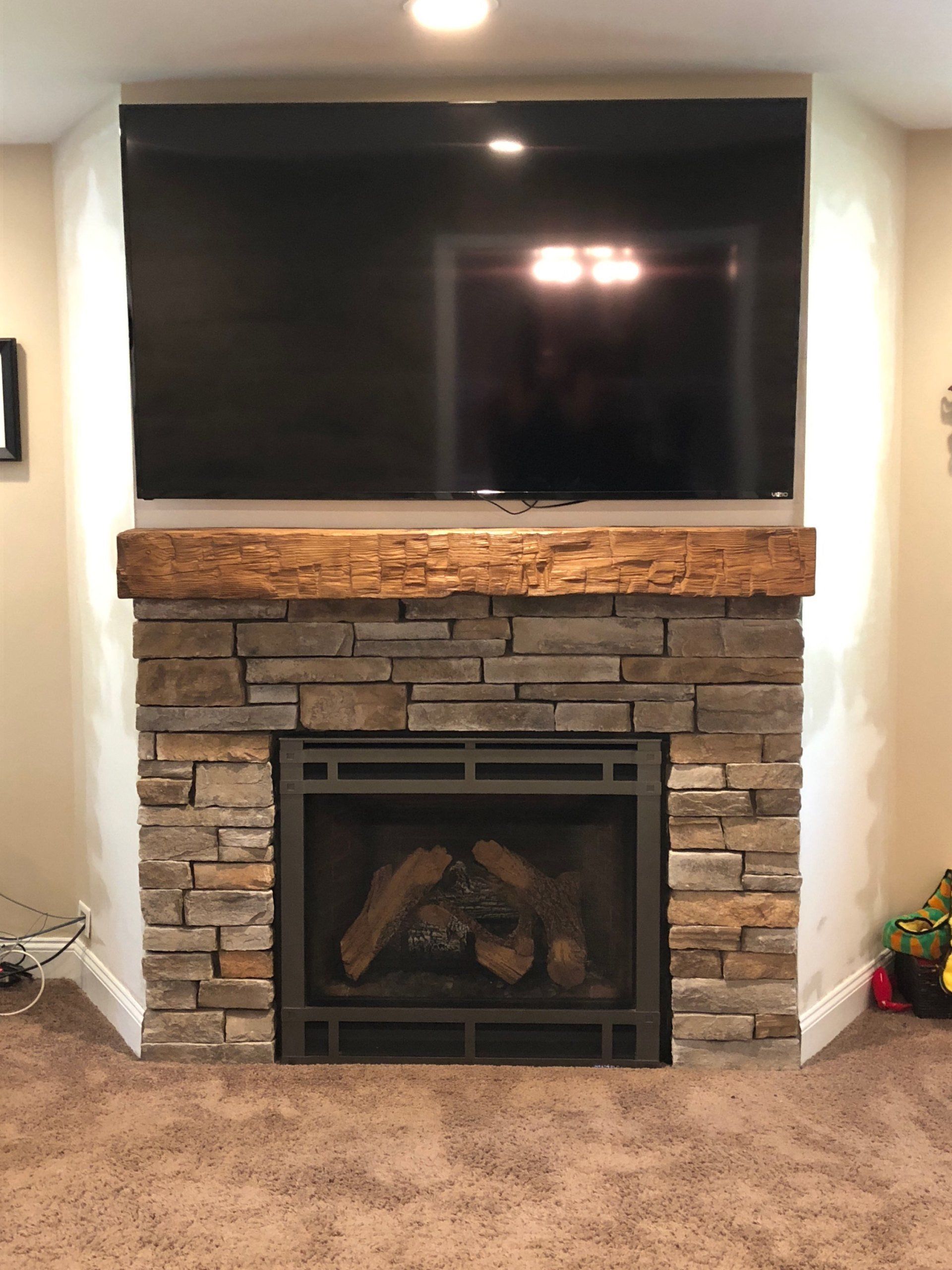 A fireplace with a flat screen tv mounted above it.