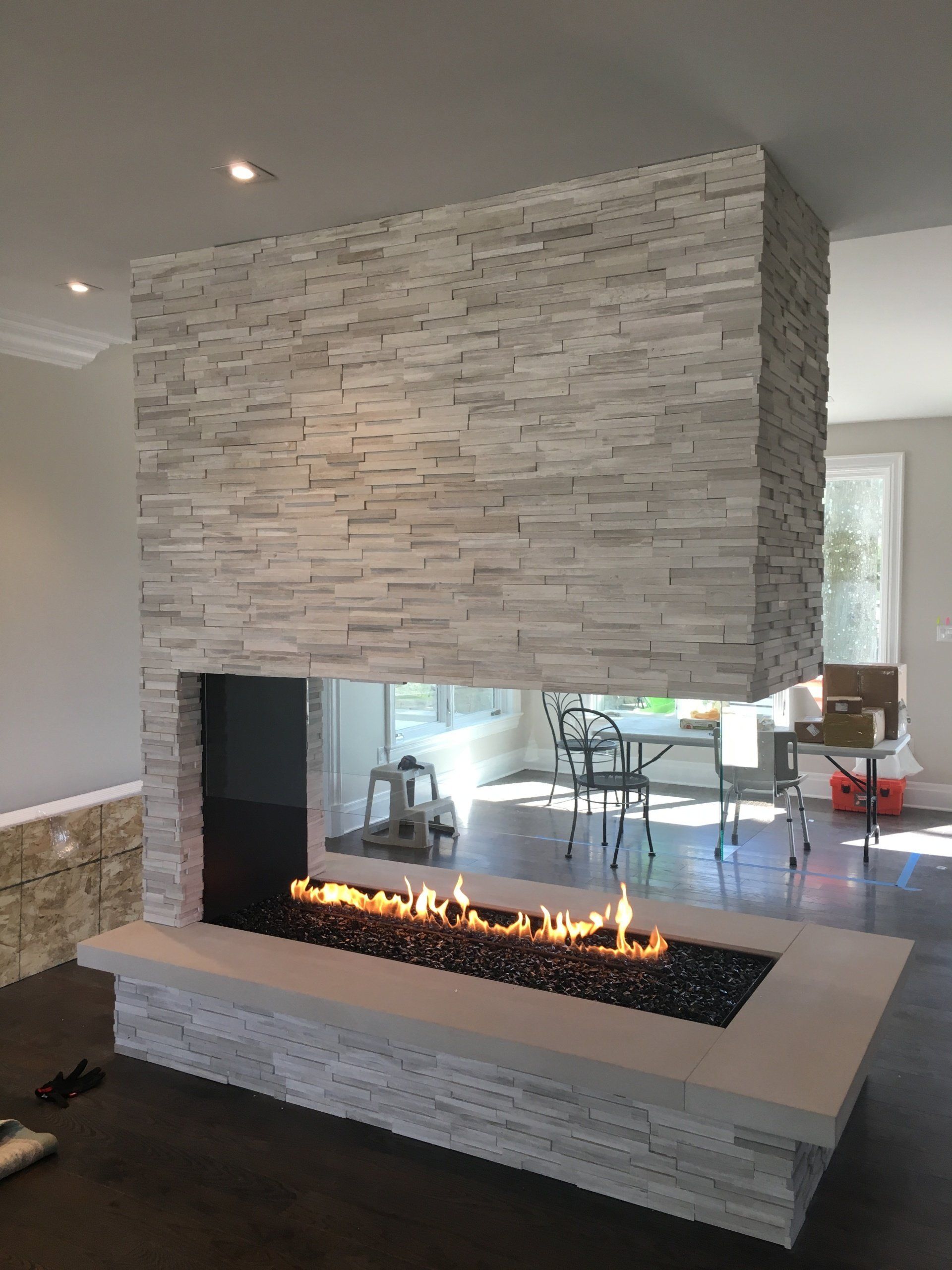 A living room with a fireplace and a brick wall