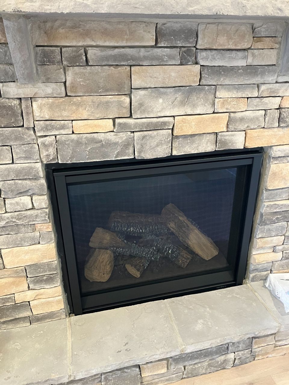 A fireplace with a brick wall and a screen on it.