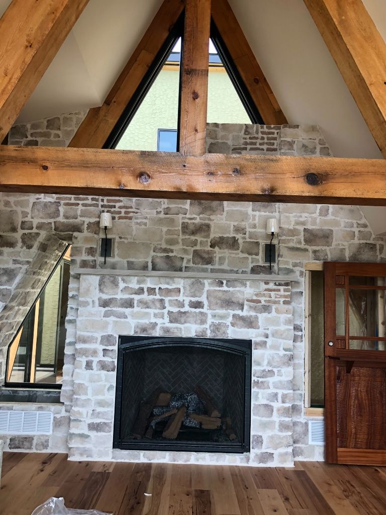 A living room with a brick fireplace and wooden beams