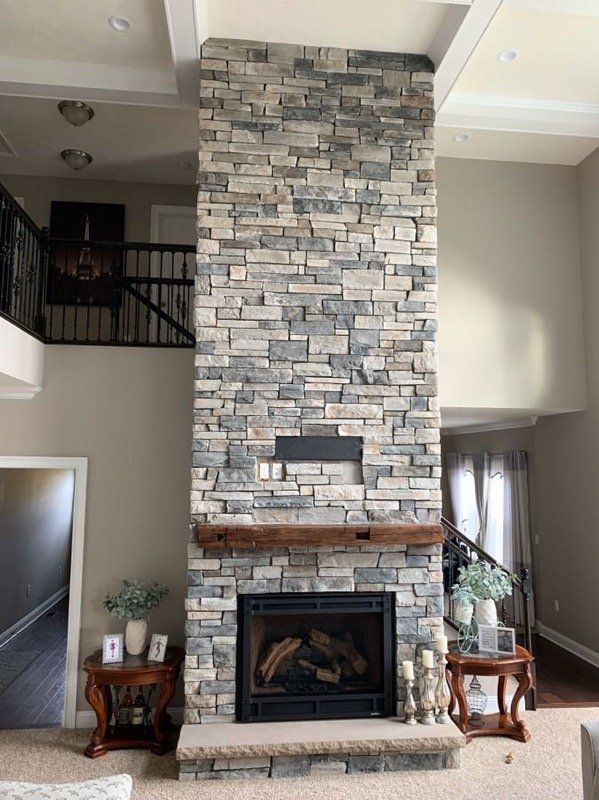 There is a large stone fireplace in the middle of the living room.
