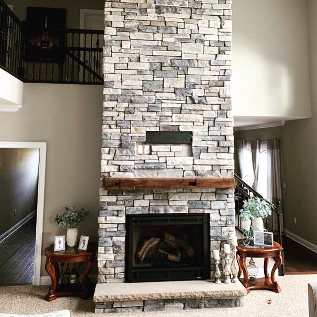 A living room with a large stone fireplace