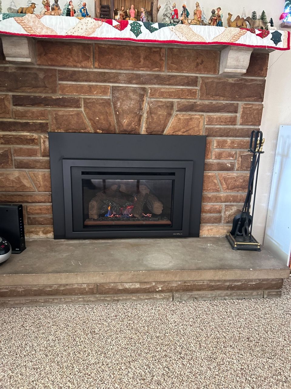 A fireplace in a living room with a black fireplace insert.
