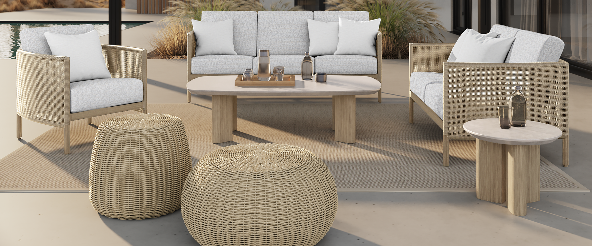 A patio with a couch , two chairs , and a coffee table.