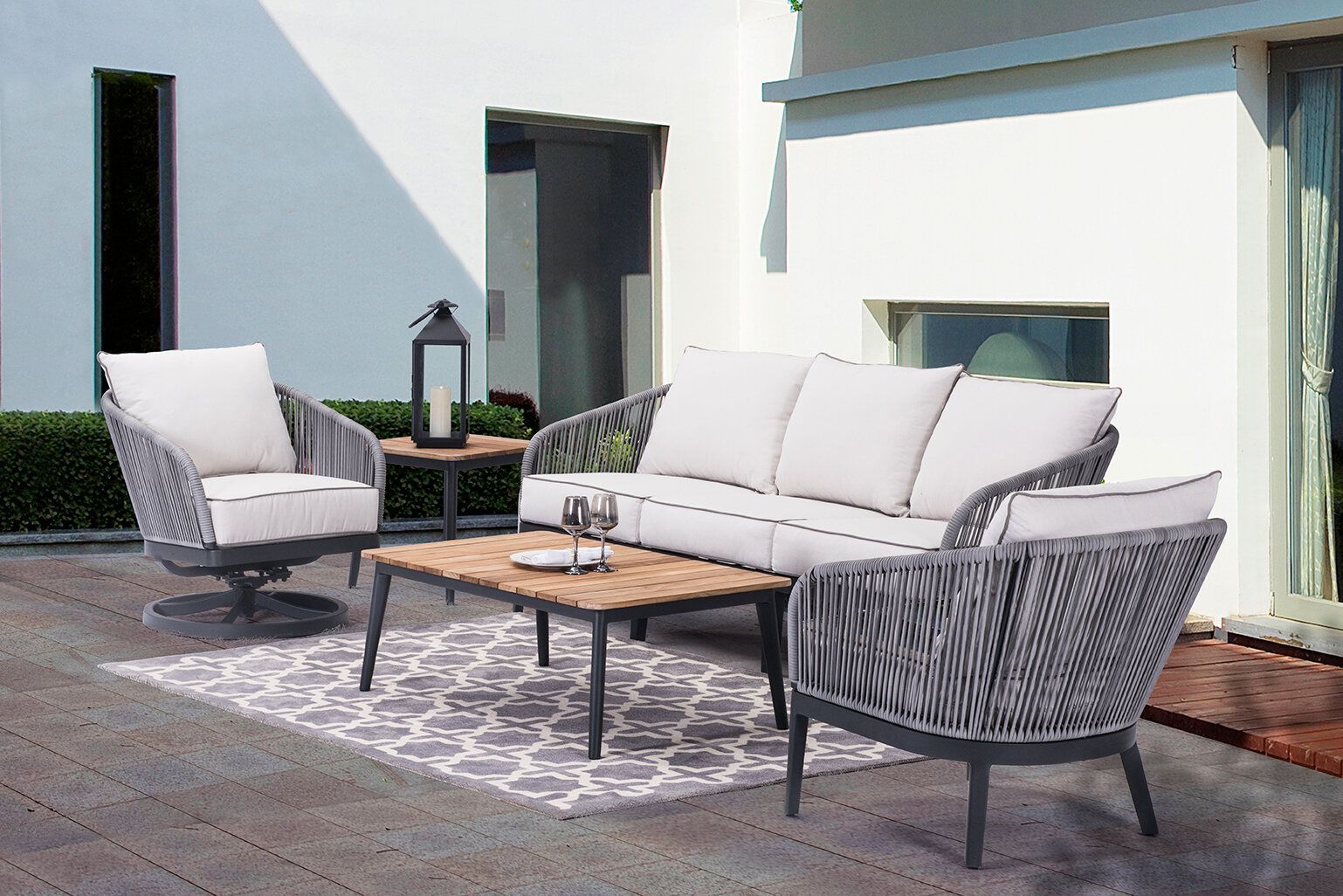 A patio with a couch , chairs , and a coffee table.
