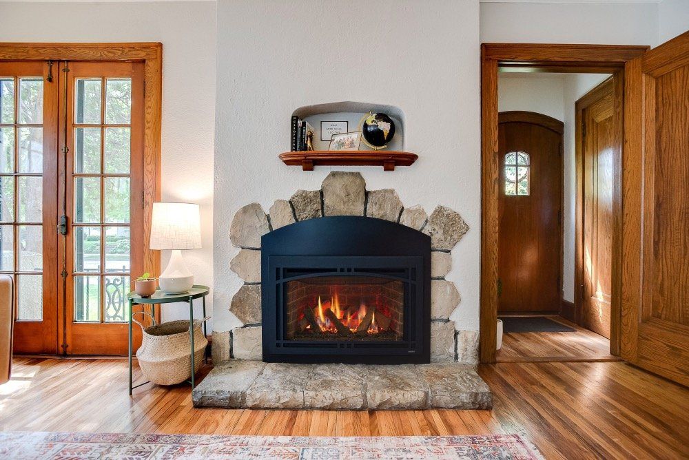 A living room with a fireplace and a wooden floor.