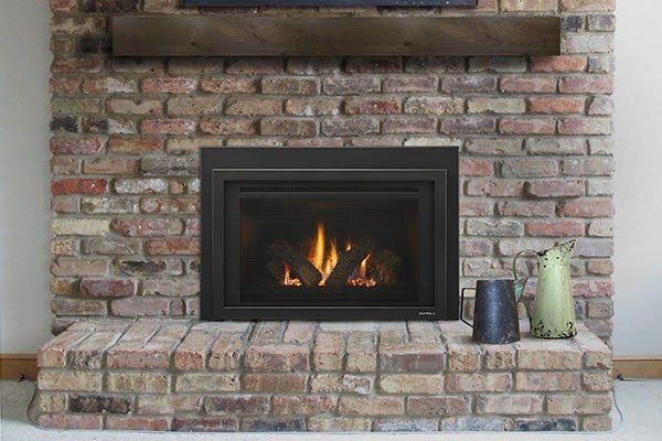 A brick fireplace with a gas fireplace insert in a living room.