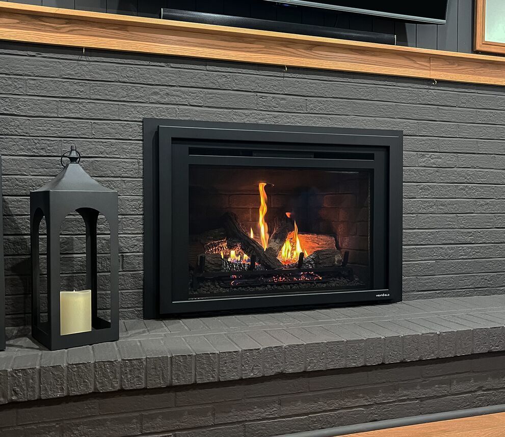 A fireplace with a lantern and a candle on it in a living room.