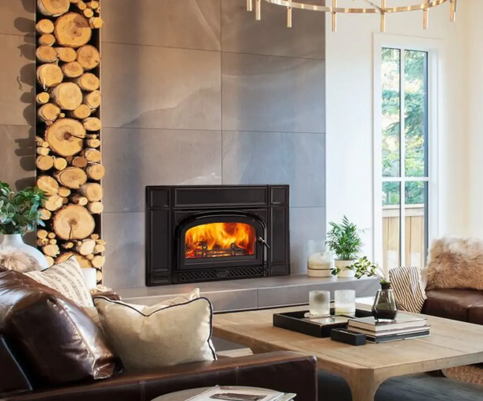A living room with a fireplace surrounded by logs