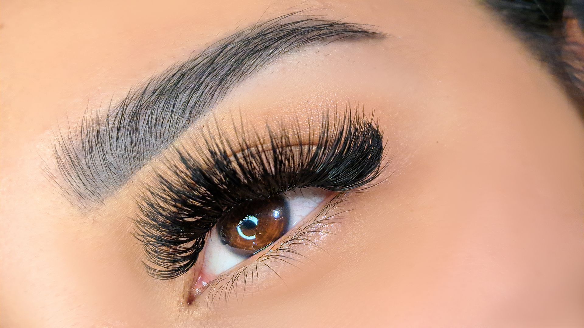 A close up of a woman 's eye with long eyelashes.