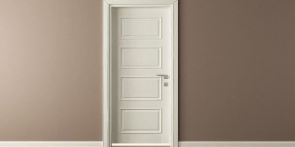 A white door is against a brown wall in an empty room.