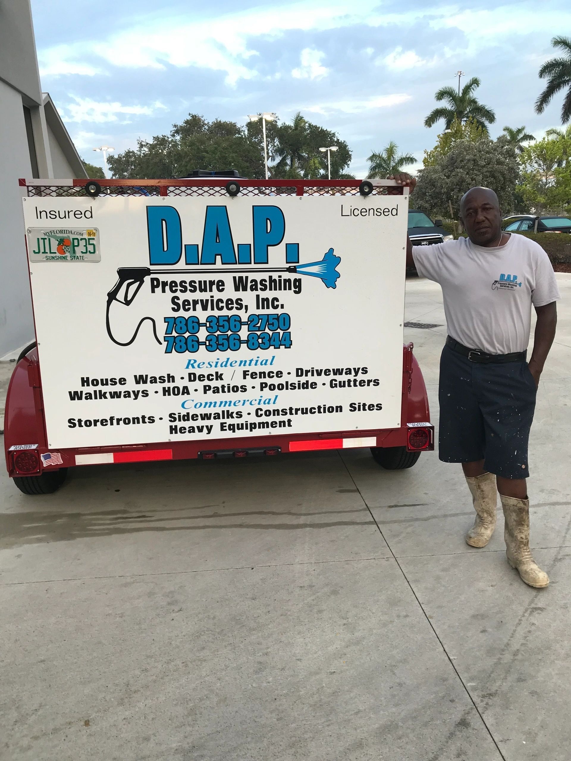 A man is standing in front of a trailer that says d.a.p.