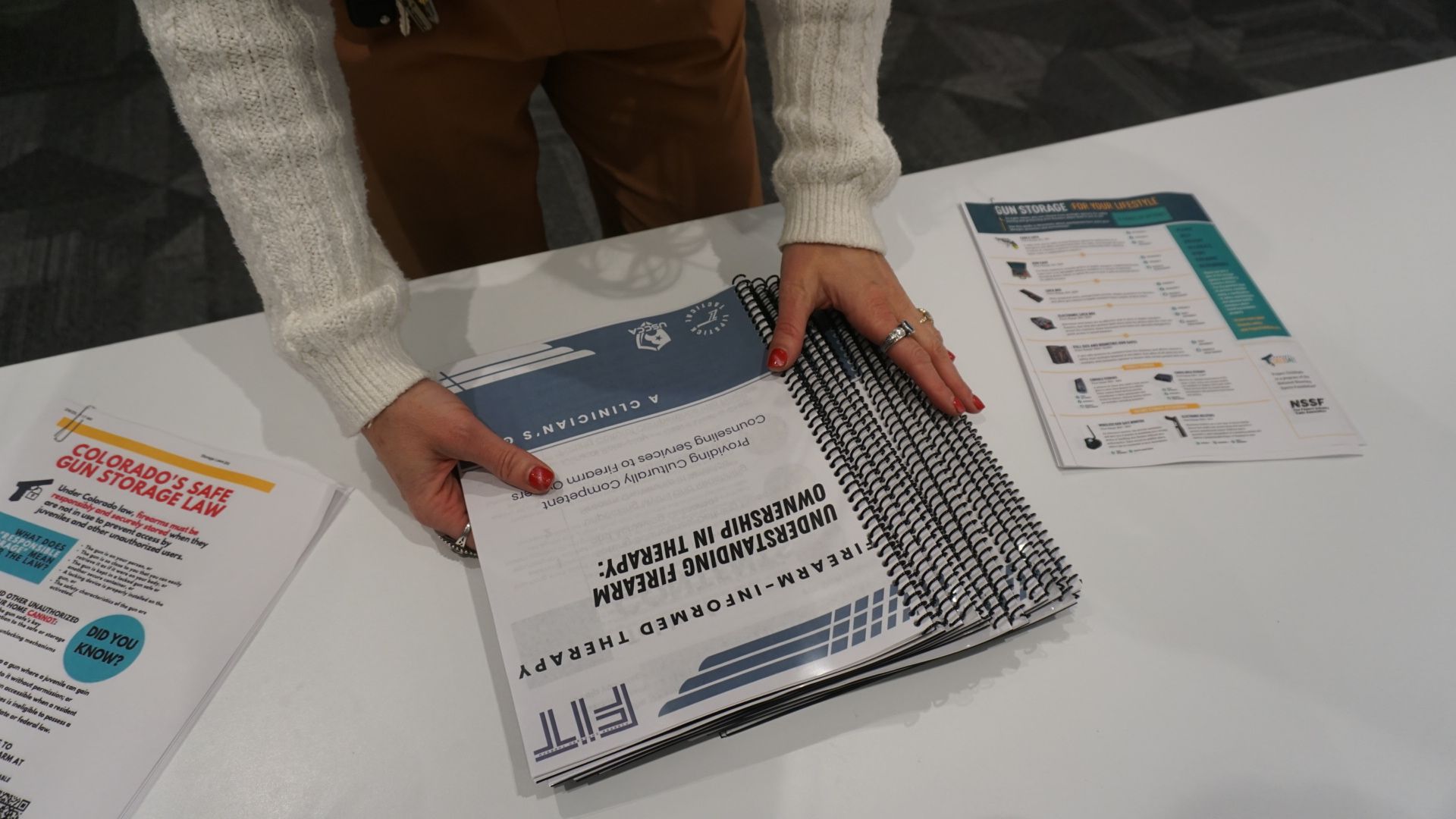 A man is holding a little girl in his arms in front of a lake.