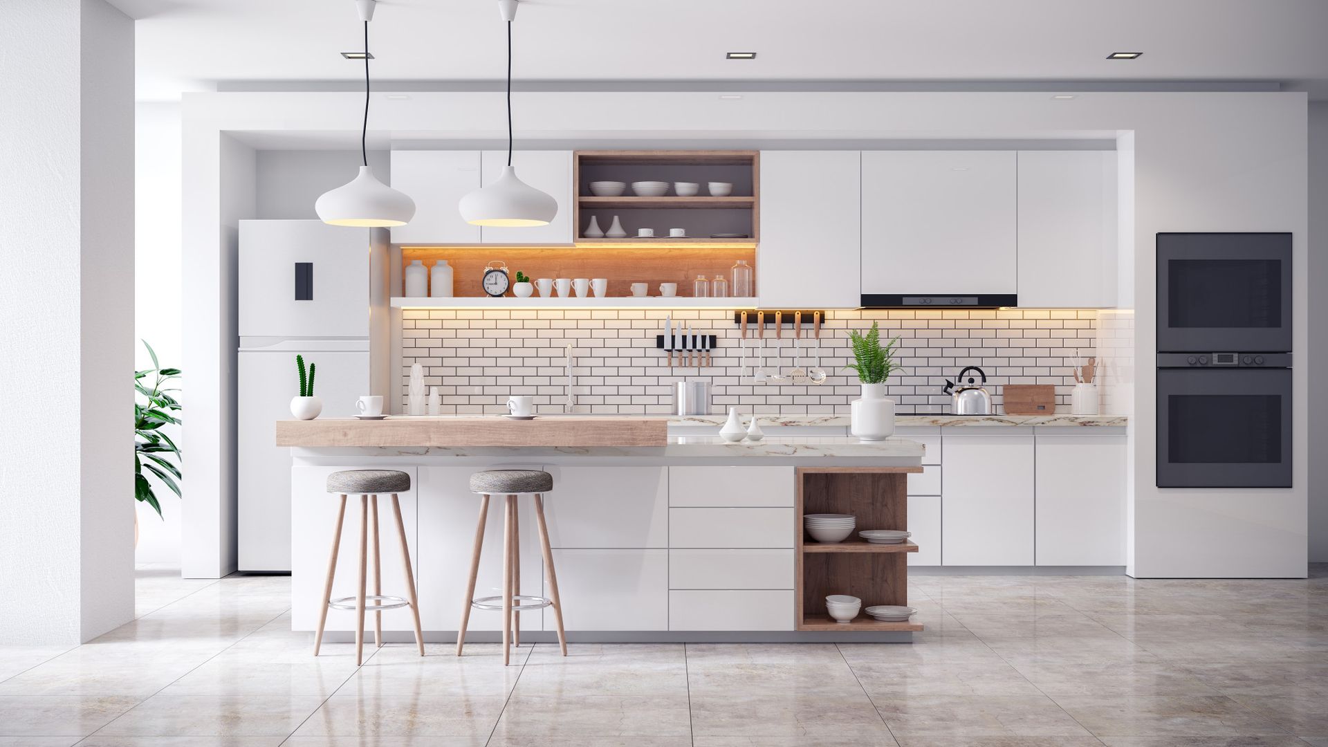 a modern kitchen with white cabinets , stools , a refrigerator , and a brick wall .