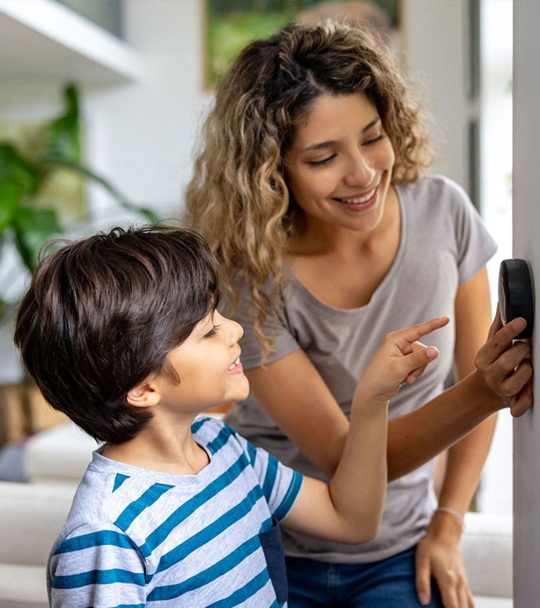 A woman and a child are looking at a cell phone.