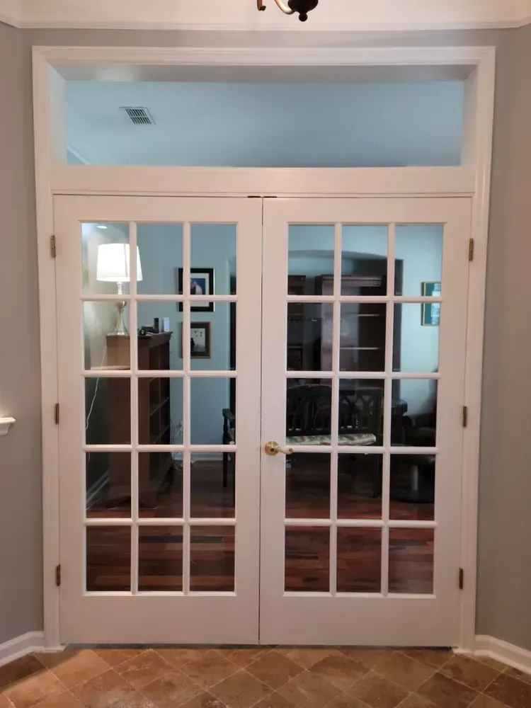 A pair of french doors open to a living room