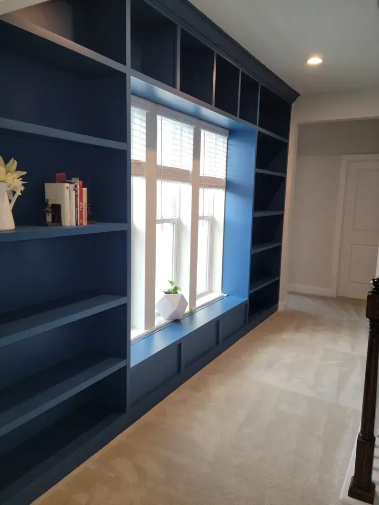 A hallway with blue shelves and a window