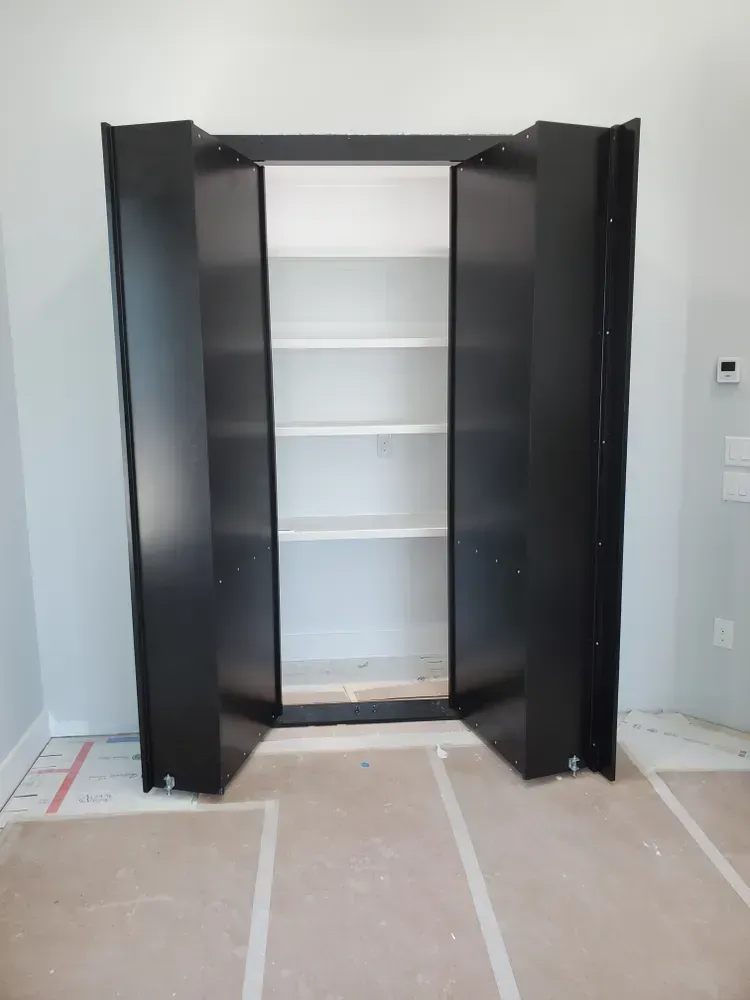 A black closet with shelves is open in a room.