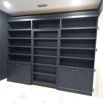 A large bookshelf with lots of shelves and cabinets in a room.