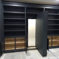 A room with lots of shelves and cabinets and a door that is open.