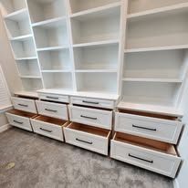 A walk in closet with lots of shelves and drawers.