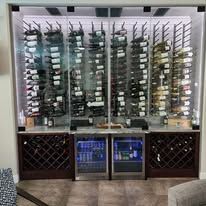 A wine cellar filled with lots of wine bottles and a refrigerator.