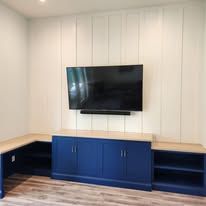 A living room with a flat screen tv mounted to the wall.