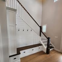 There is a bench under the stairs in the hallway.