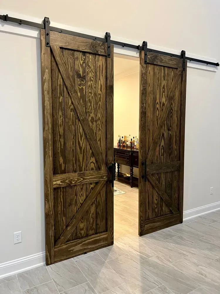 A pair of wooden sliding barn doors are open in a room.