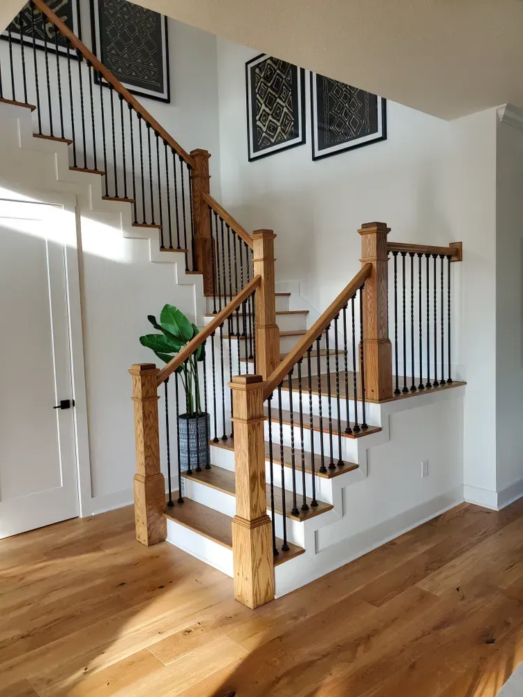 A wooden staircase with a metal railing in a house