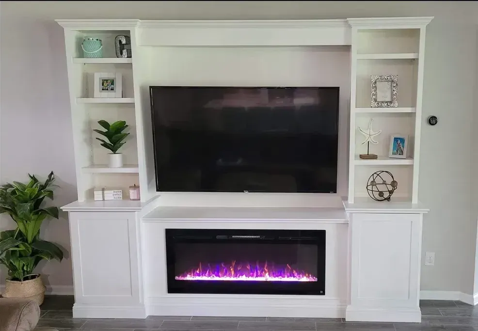 A living room with a fireplace and a flat screen tv.