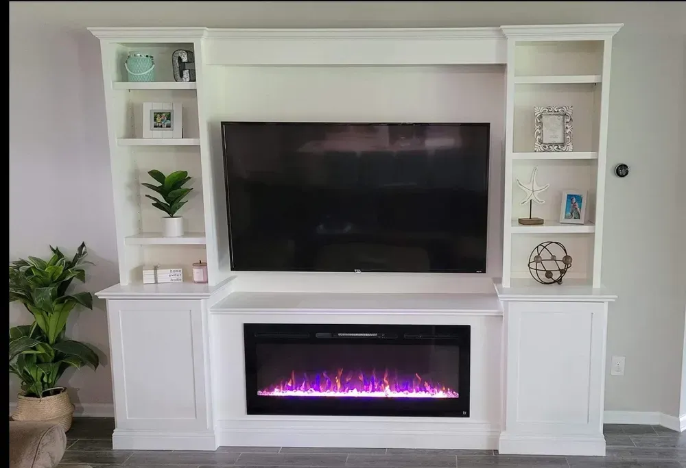 A living room with a fireplace and a flat screen tv.