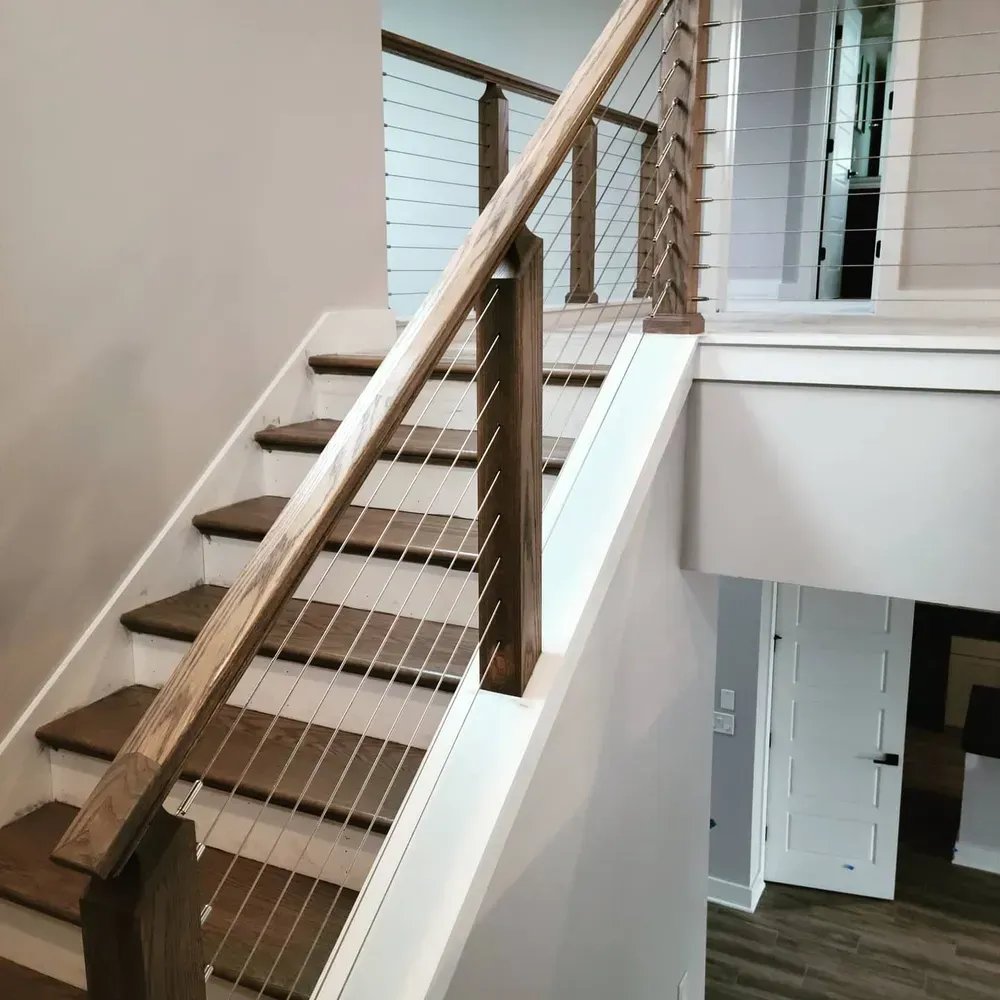 A staircase with a wooden railing and a wire railing