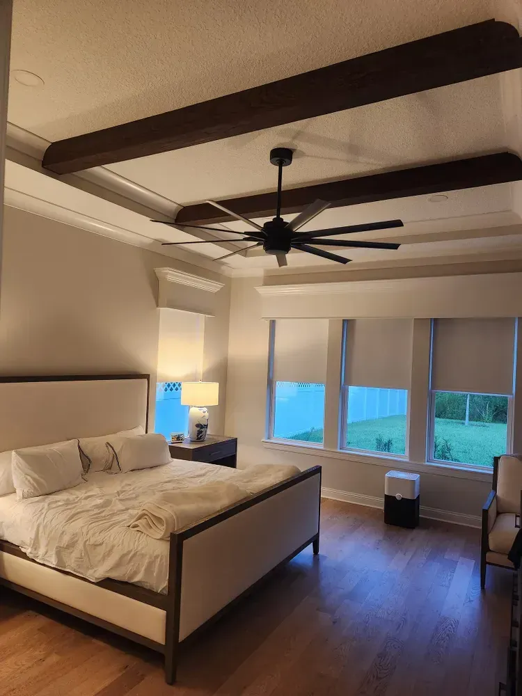 A bedroom with a large bed and a ceiling fan