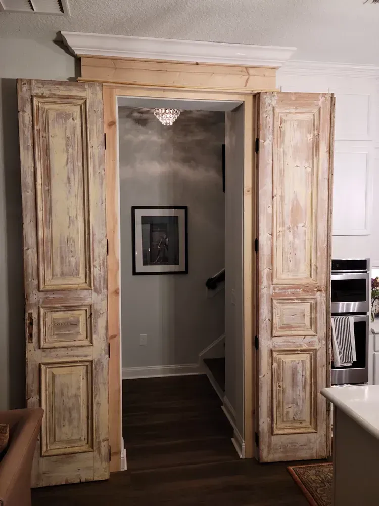 A hallway with a picture on the wall behind the doors