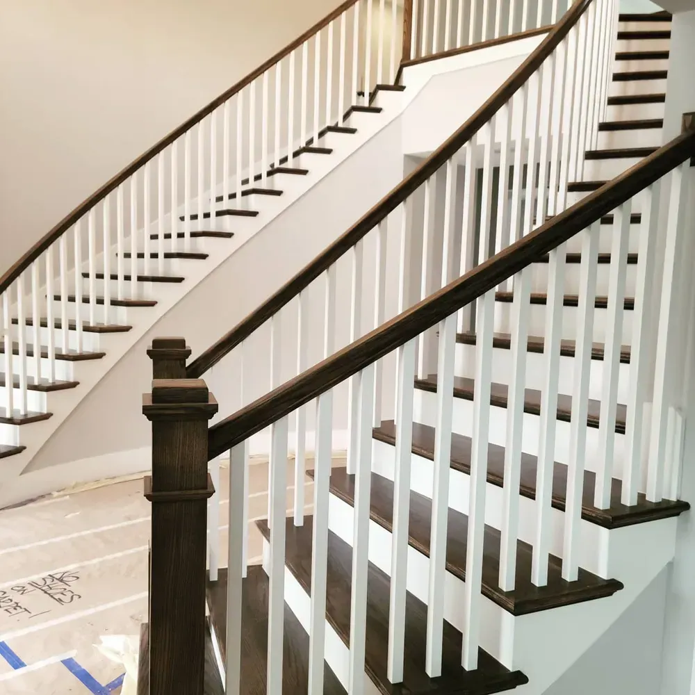 A staircase with a white railing and brown steps