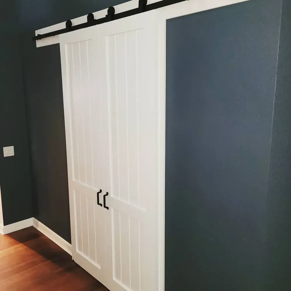 A white sliding barn door in a dark room